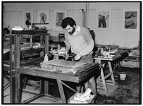 841672 Afbeelding van een lithograaf tijdens het prepareren van een lithosteen in het Grafisch Atelier (Pieterskerkhof ...